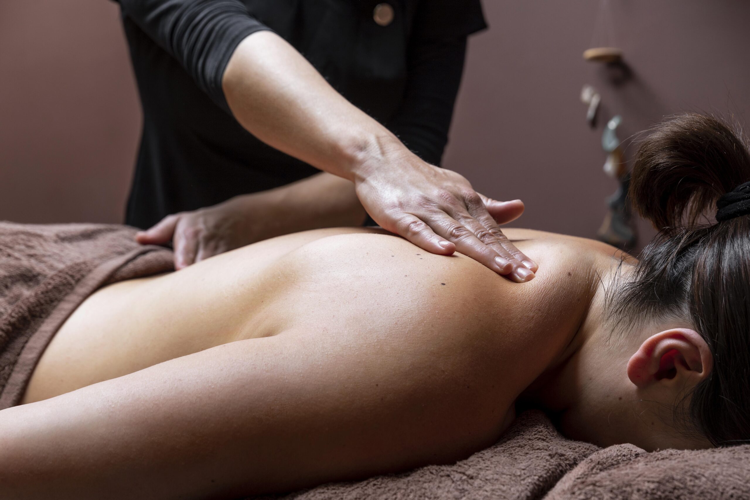 Personne recevant un massage Amma assis sur une chaise ergonomique, dans une posture relaxante. Les gestes précis et rythmés du masseur servent à soulager les tensions et à stimuler l'énergie vitale, dans un cadre professionnel et apaisant.